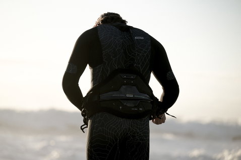 Harnais de taille ION Apex en noir avec soutien lombaire Ergo Pad pendant le kitesurf en mer
