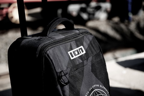 ION Carry-on Wheelie hard-bottom trolley suitcase in black with extended handle during travel