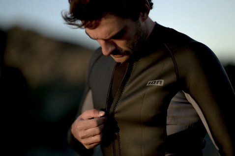 ION Neo Zip Top 2/1 LS Skin top in neoprene a maniche lunghe verde oliva scuro indossato sulla costa