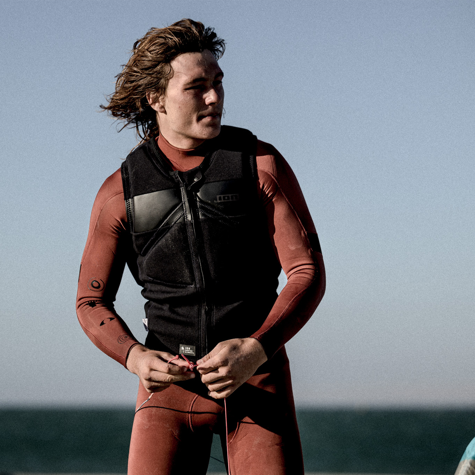 ION Vector Vest Select front-zip impact vest men in black, worn on model at the beach