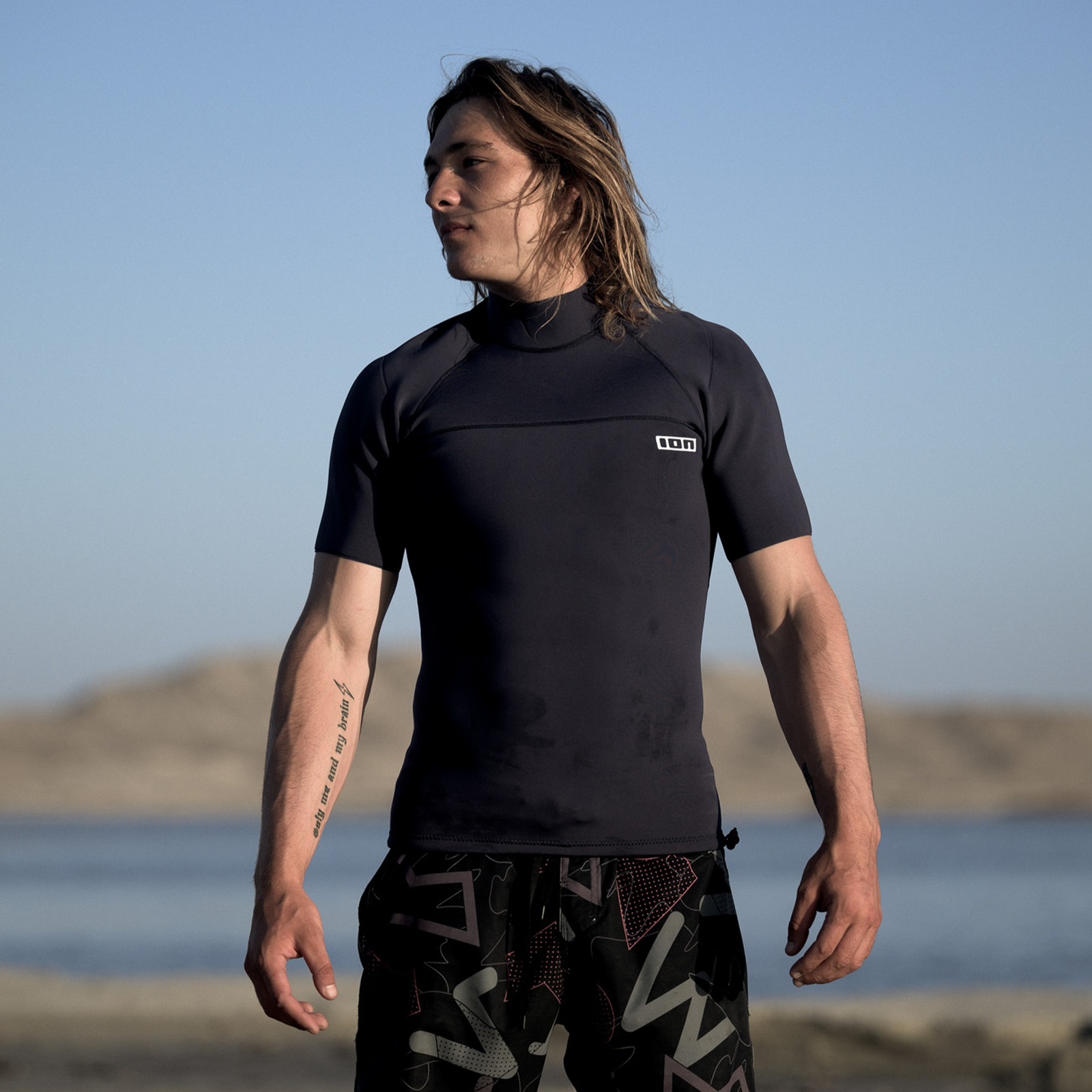 ION Neo Top 0.5 short-sleeve neoprene top in black worn at the beach