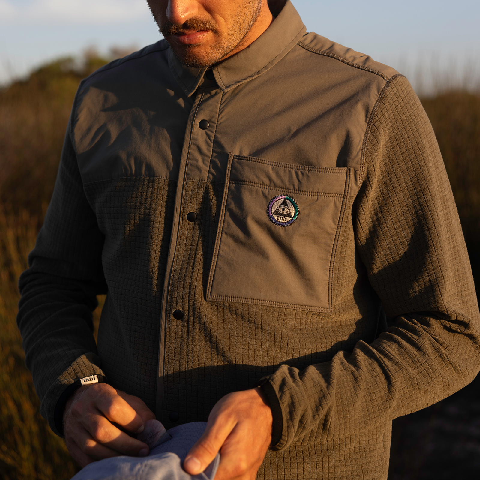 Giacca unisex ION Ionic Fleece in oliva scuro indossata all'aperto
