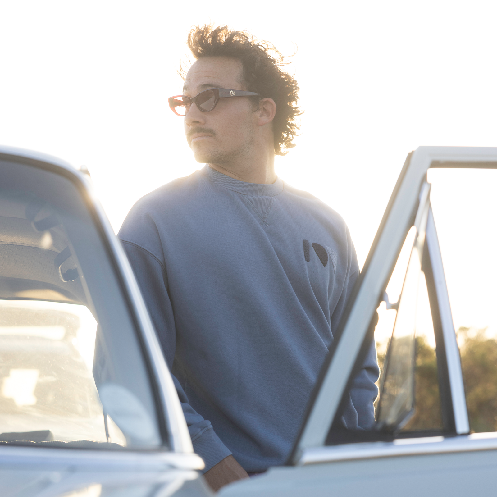 Sweat ION Mood homme en bleu ardoise porté en extérieur à la lumière dorée