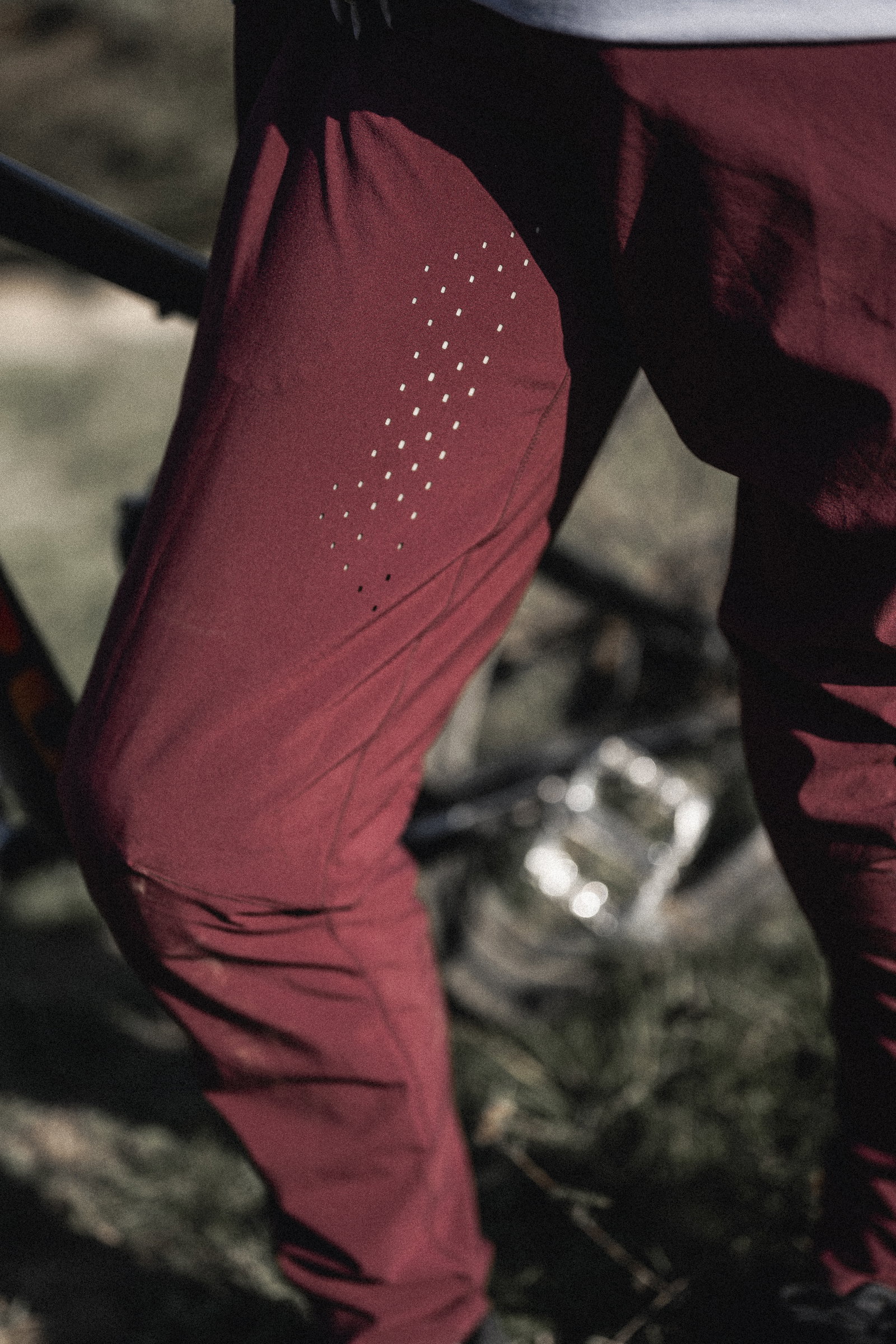 ION Ionic LT women MTB pants in burgundy with laser-cut venting during mountain biking in forest
