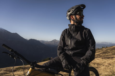 ION Bike Shelter 2L softshell pants in black during mountain biking in an alpine landscape