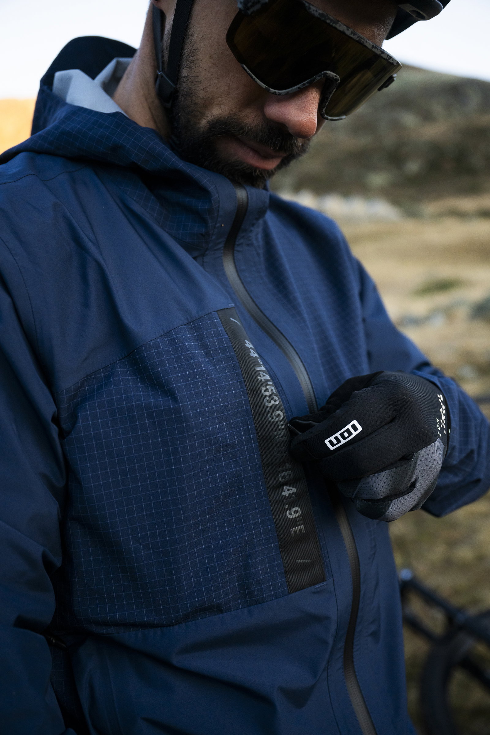 ION Bike Shelter 3L cycling jacket in navy blue during mountain biking on a highland trail