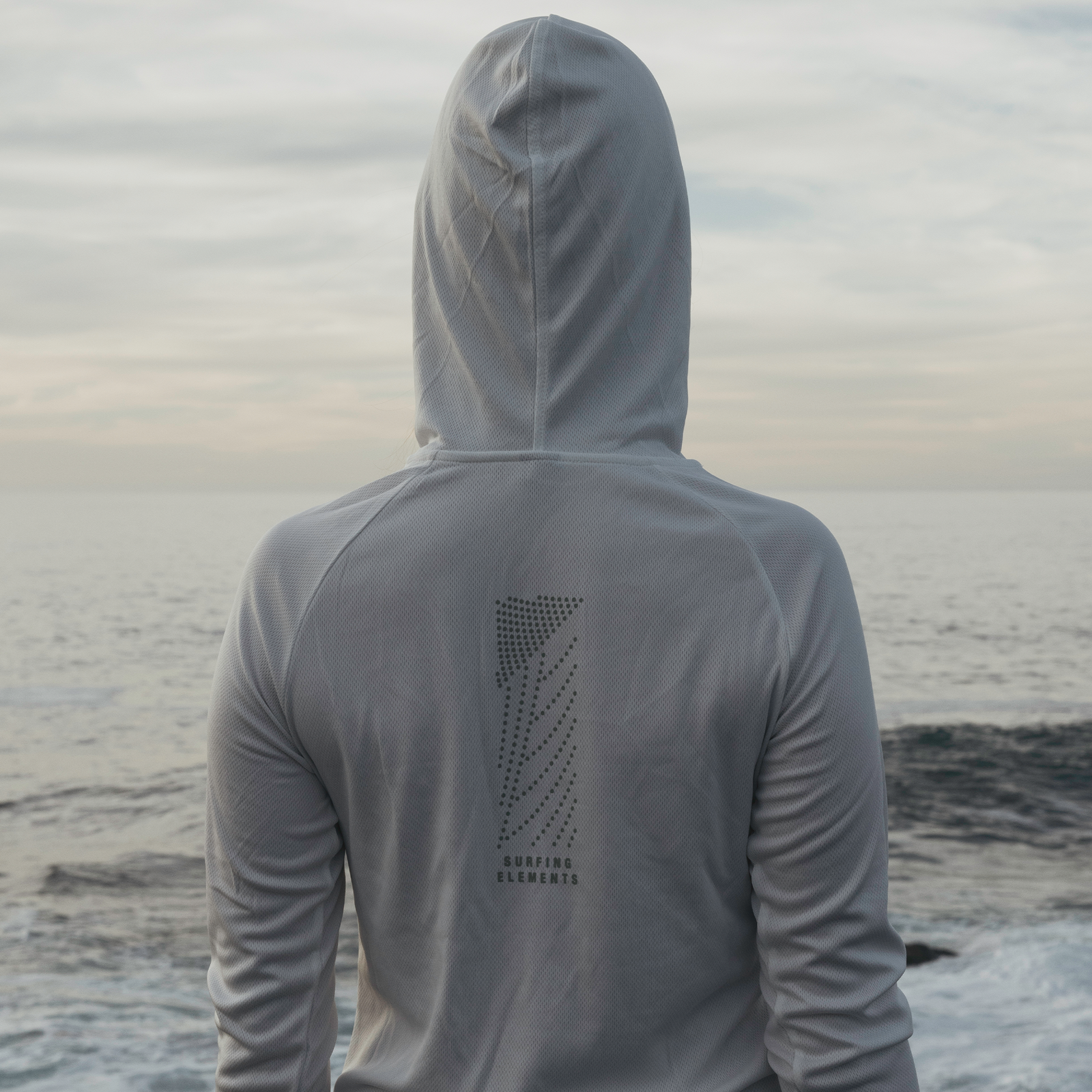 ION Wetshirt Hood LS women long-sleeve hooded top in light grey during kitesurfing at the coast