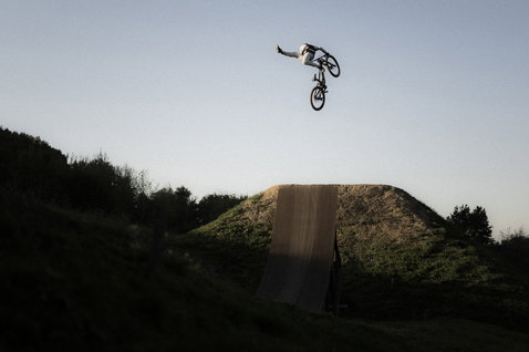 ION Bike Scrub Amp LS BAT long sleeve jersey during freeride mountain biking at a dirt jump park