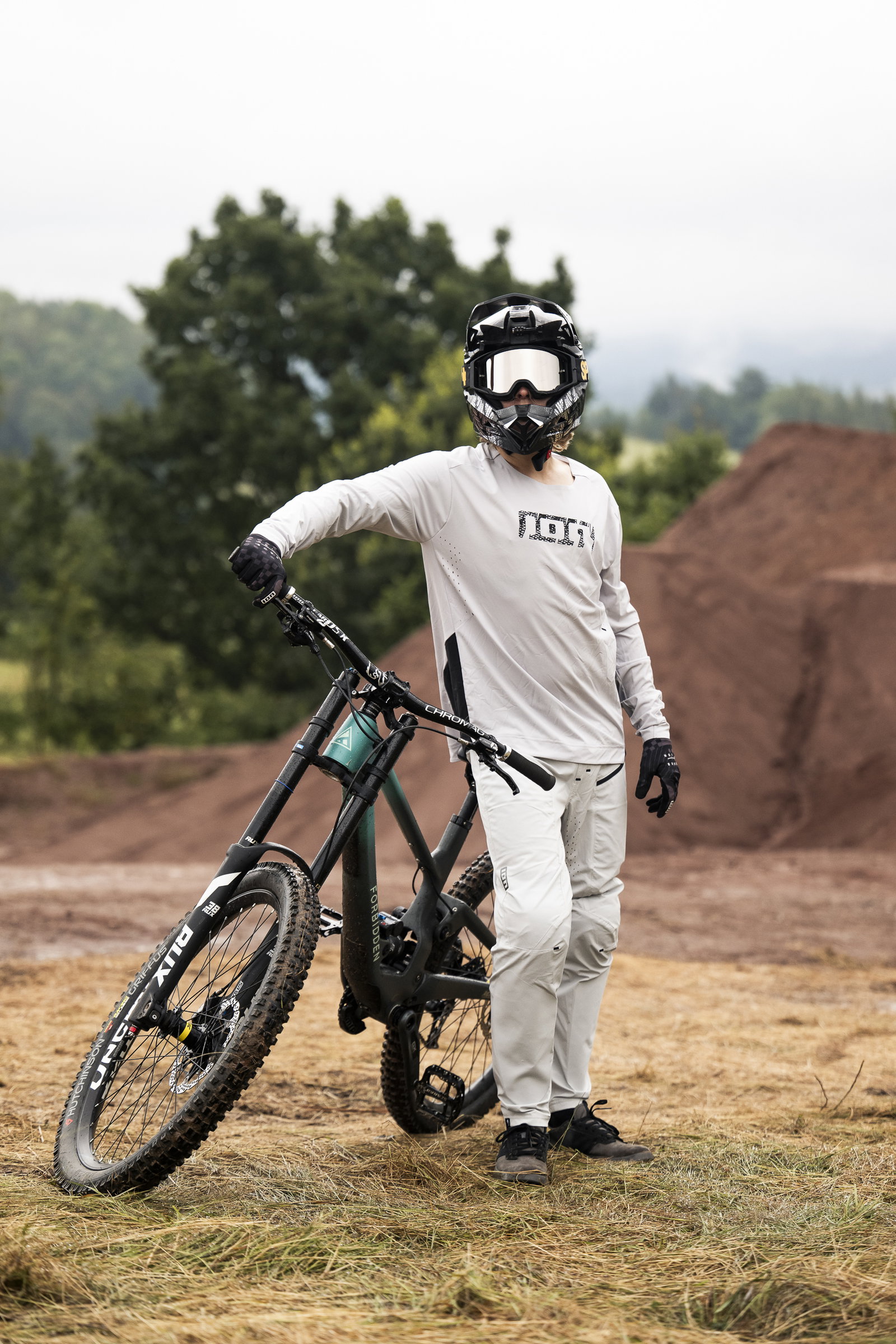 ION Scrub Amp BAT long sleeve cycling jersey in off-white during freeride mountain biking at a dirt park