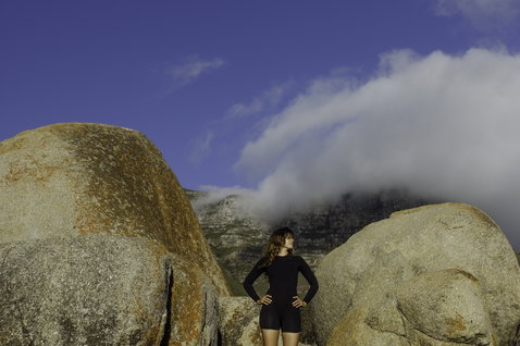 ION Amaze Amp Shorty 2.0 LS Back-Zip Neoprenanzug in schwarz beim Surfen an der Felsenküste