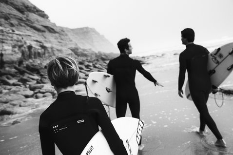 ION Capture Amp 4/3mm front-zip junior fullsuit in black during wave surfing at the coast