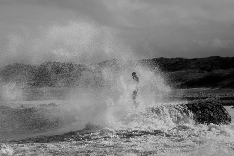 ION Hoody Neo Lite women's neoprene hoody during watersports in dramatic ocean surf