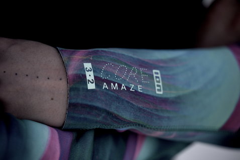 ION Amaze Core 3/2mm front-zip fullsuit detail in dark black with abstract teal and purple print