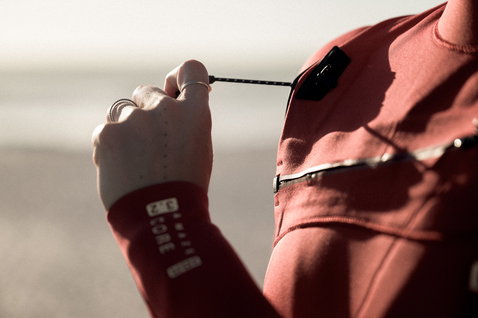 ION Amaze Core 3/2mm front-zip fullsuit wetsuit in terracotta red worn at the coast