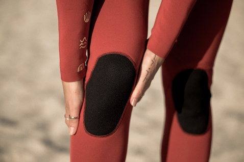ION Amaze Core 3/2mm front-zip fullsuit in deep red with black knee pads, detail view
