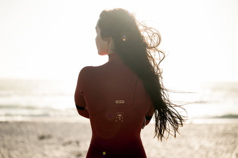ION Amaze Core 3/2mm front-zip fullsuit in dark burgundy during beach lifestyle at the ocean