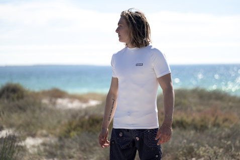 ION short-sleeve rashguard men in white during a sunny beach day at the ocean
