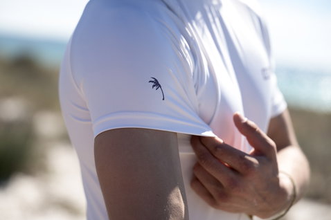 ION short sleeve rashguard men in white with palm tree print on sleeve at the beach