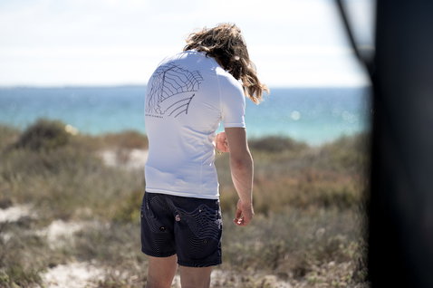 ION short sleeve rashguard men with back graphic print at the beach in white