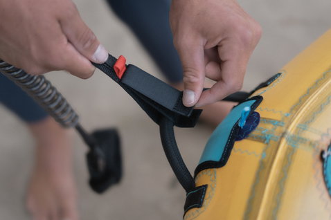 ION Wing Leash Core Coiled Wrist leash in nero con polsino in neoprene turchese durante il wing foiling