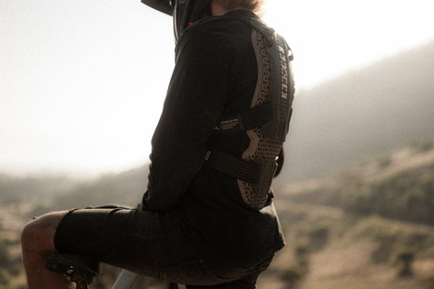 ION Bike ARCON HD PRO chest and back protector in black during mountain biking on a hillside trail