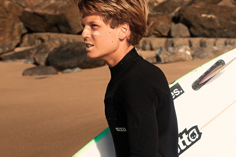 ION Capture Amp 4/3mm front-zip junior fullsuit in black during wave surfing at the beach