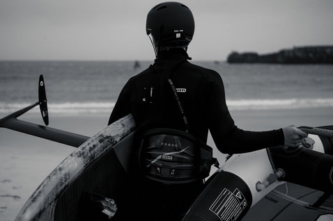ION Rogue Hüfttrapez beim Wing Foiling am Strand mit CURV-Rückenschale