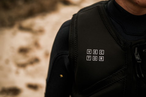 ION Vector Core Front Zip impact vest in black during kiteboarding at the beach