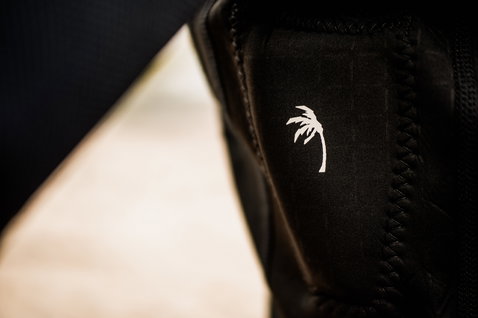 ION Vector Vest Core Front Zip impact vest in black, detail view showing palm tree logo