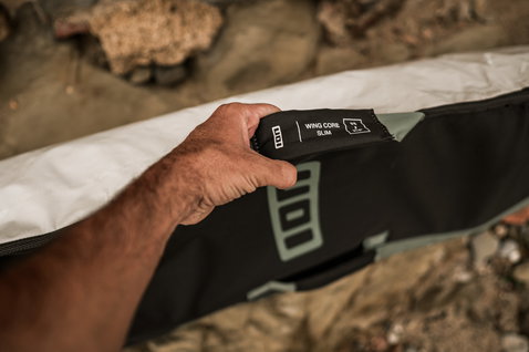 ION Wing Core Slim wing boardbag 5'6 x 21.5" in off-white and black detail shot at beach