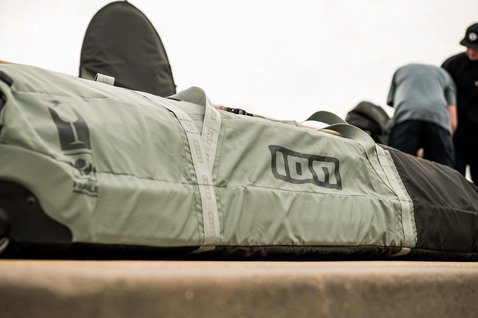 ION Gearbag Core kite gear bag in sage green and dark grey during kitesurfing trip at the coast