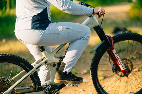 ION Scrub Amp BAT women's long-sleeve cycling jersey in light grey during mountain biking in the forest