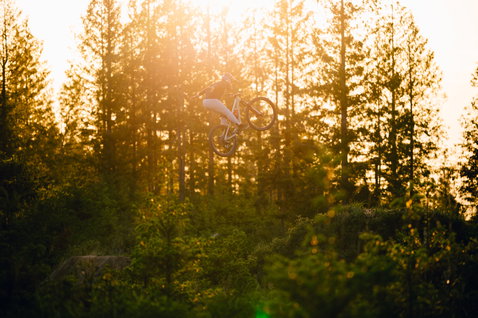 ION Scrub Amp BAT women bike pants during mountain biking in forest at golden hour