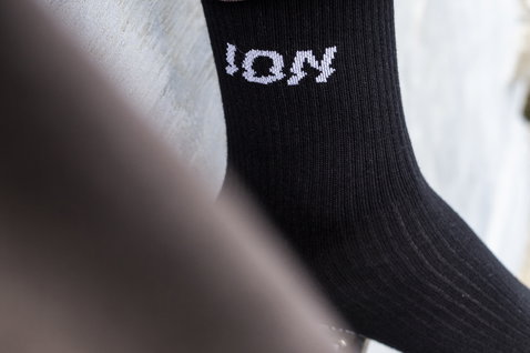 Calzini ION Ionic Light in nero con logo ION lavorato a maglia, indossati sulla gamba in Islanda