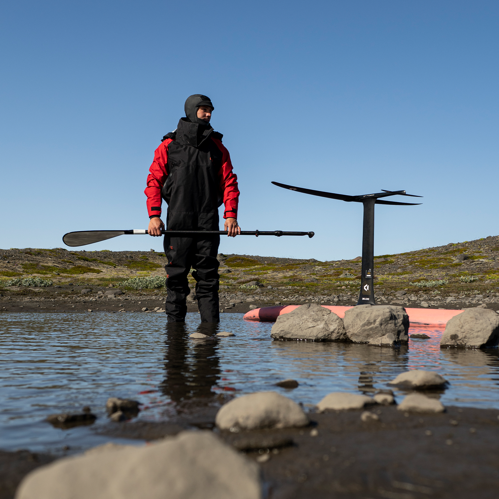 ION Fuse Lightweight Drysuit back zip unisex in black and red during foiling at a mountain lake