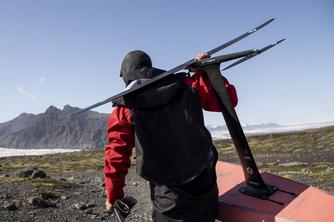ION Fuse Lightweight drysuit back-zip in black and red during wing foiling in Iceland
