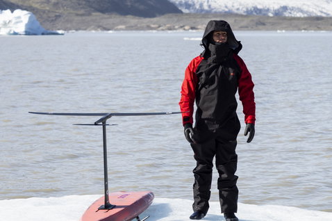 ION Fuse Lightweight Drysuit back zip in black and red during wing foiling on a glacial lagoon in Iceland
