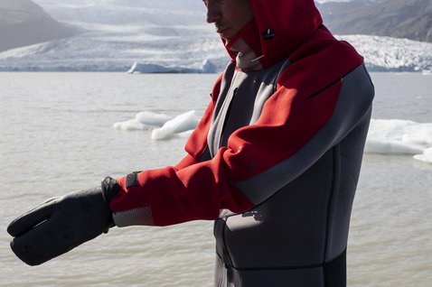 ION Fuse Drysuit 4/3mm back-zip fullsuit in charcoal and red during kitesurfing at Iceland glacier lagoon