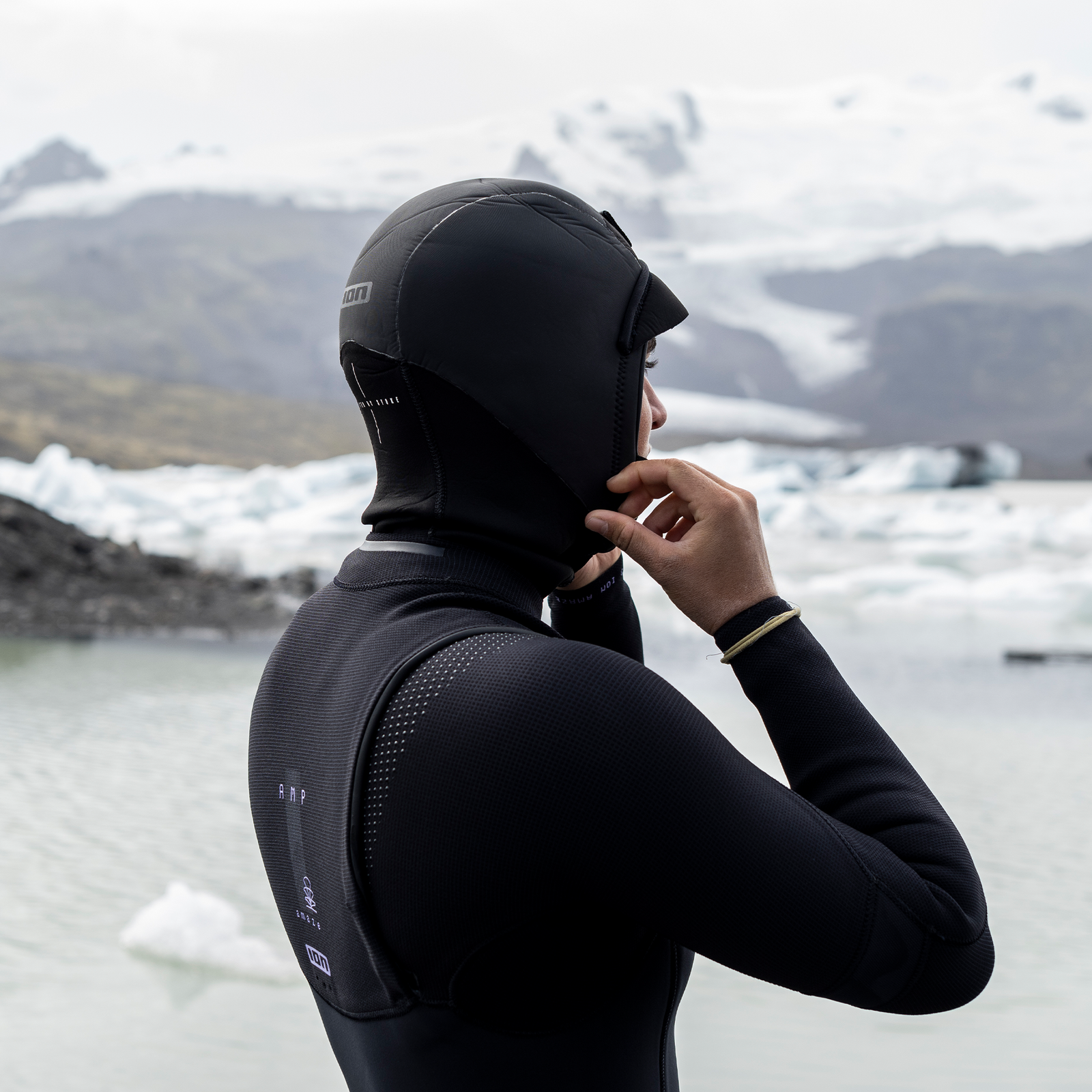 ION Neo Hood cagoule néoprène 3/2 mm en noir lors d'une session kitesurf en eau froide sur un lagon glaciaire