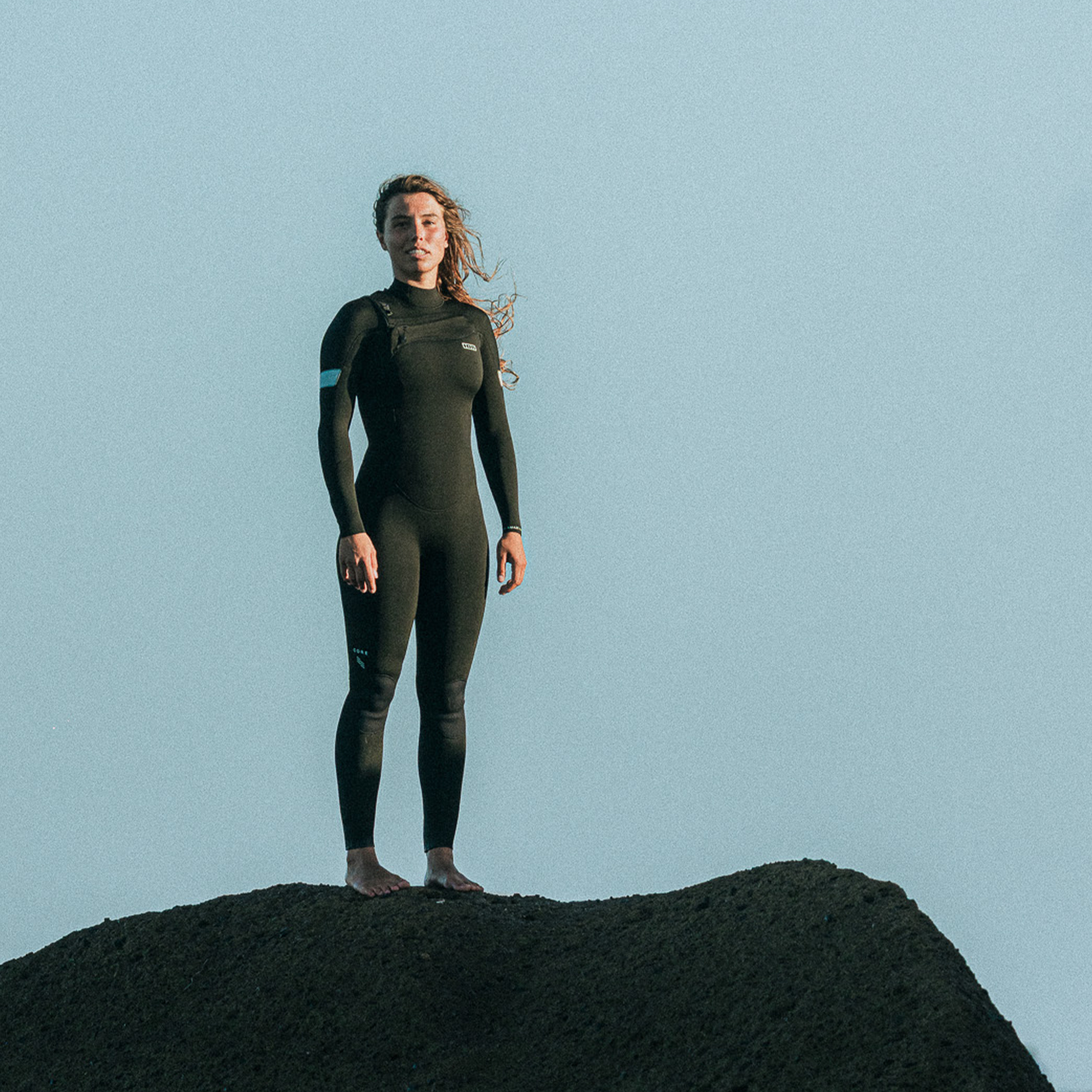 ION Amaze Core 5/4mm front-zip women's fullsuit wetsuit in black at a coastal location