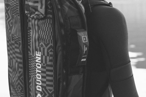 ION Pump Foil Boardbag Tec 3'4'' in black being carried outdoors