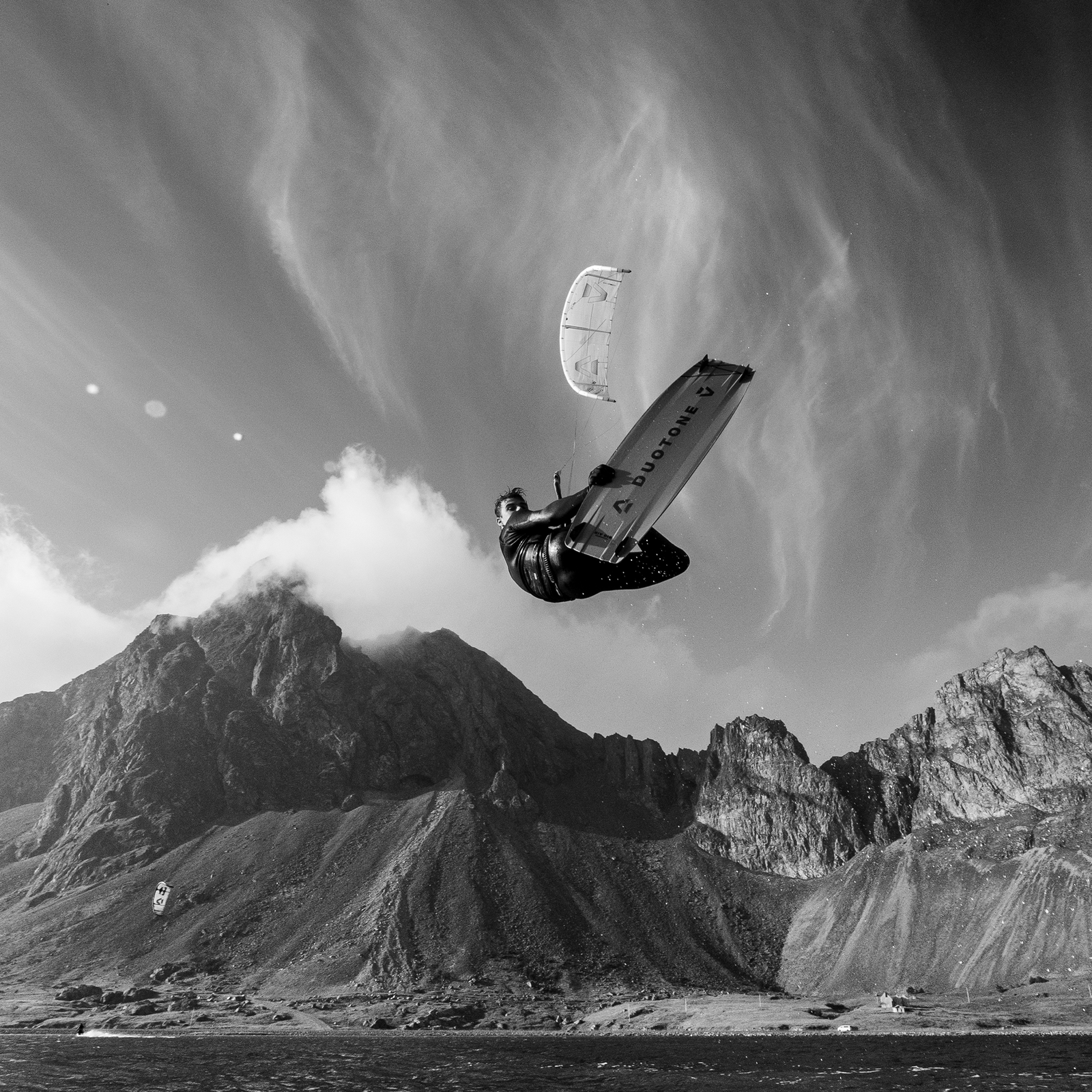 ION Spectre arnês de cintura com casco rígido de carbono durante kitesurf sobre paisagem costeira