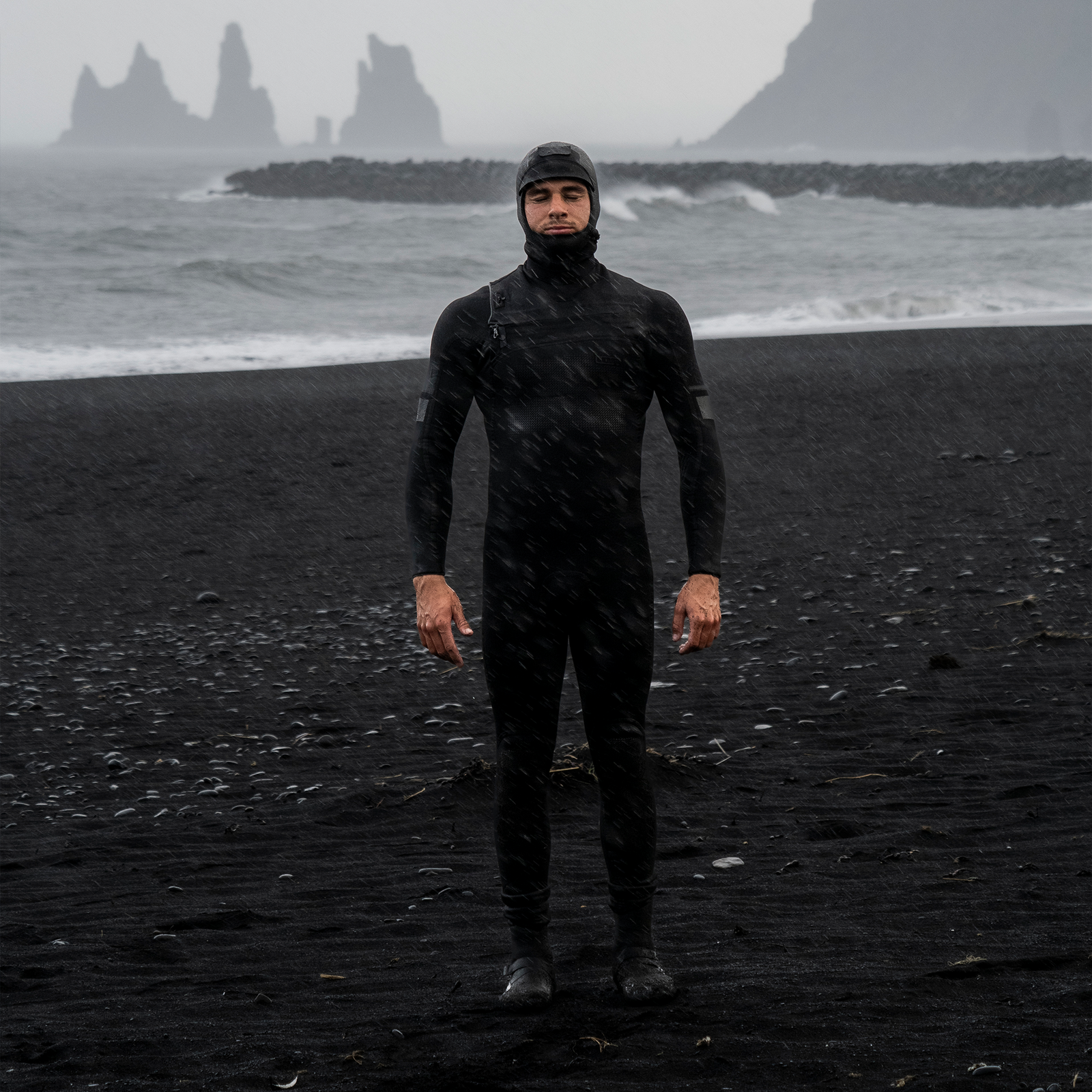 ION Seek Select 5.5/4.5mm front-zip hooded fullsuit men in black during surfing at the beach