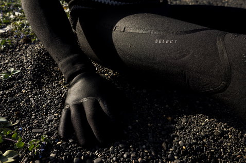 ION Seek Select muta integrale front-zip con cappuccio 5,5/4,5 mm in nero durante il surf d'onda in Islanda
