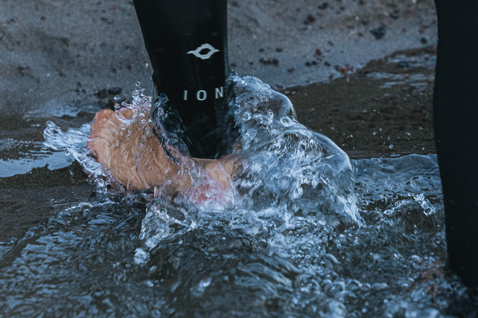 Muta ION Seek Core 5/4mm zip frontale da uomo in nero durante una sessione in acqua