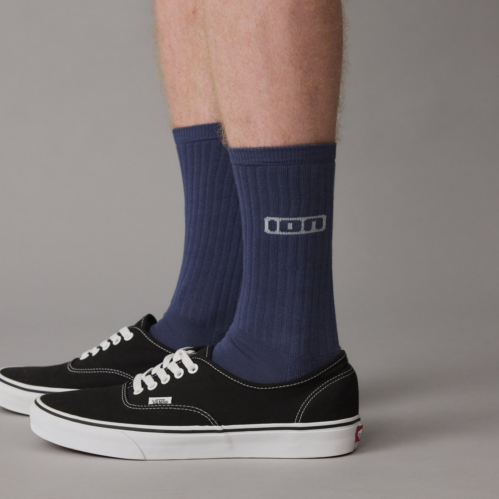 ION Ionic lange Socken unisex in marineblau, getragen mit schwarzen Sneakern im Studio