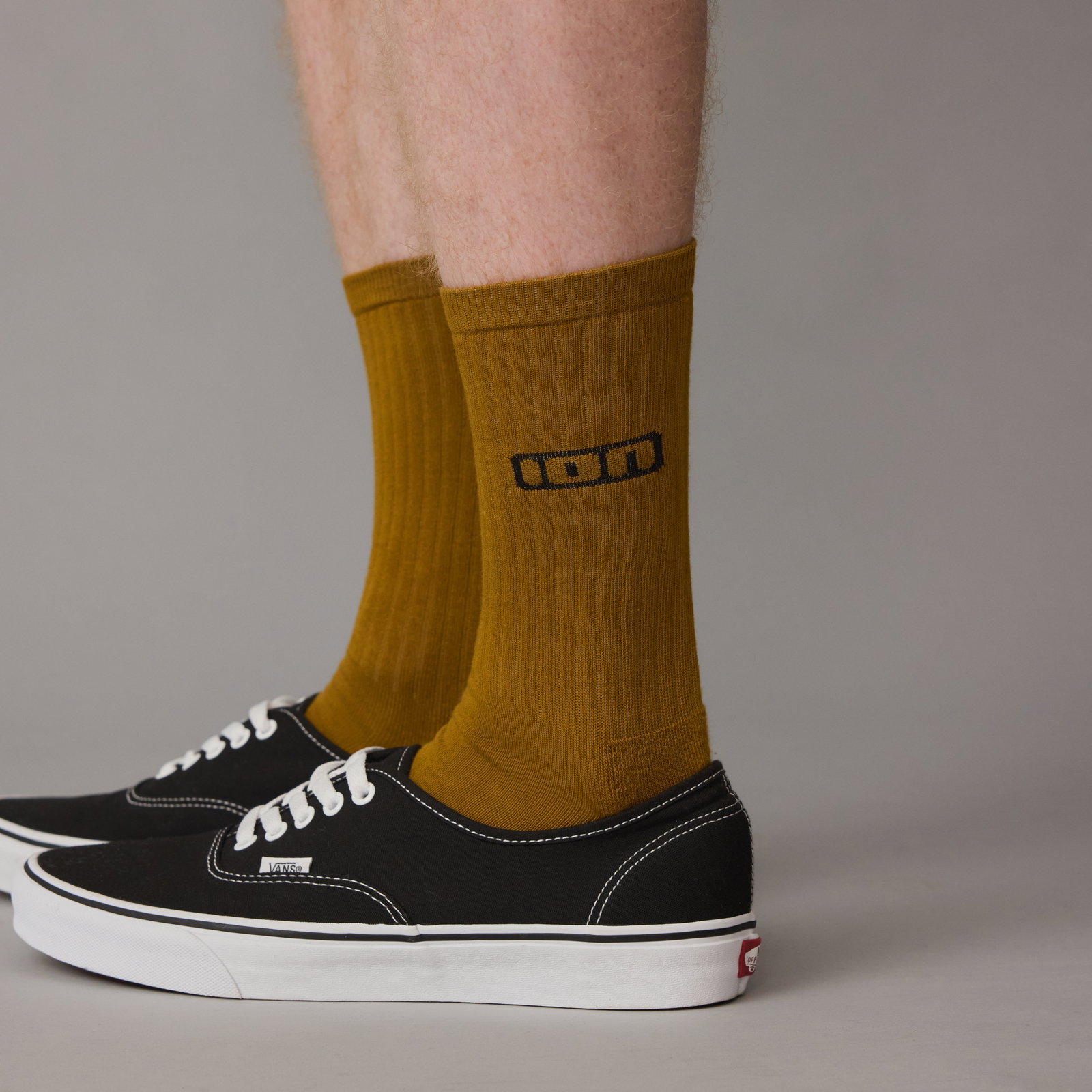 ION Ionic Socken lang unisex in olive, getragen am Fuß mit schwarzen Sneakern