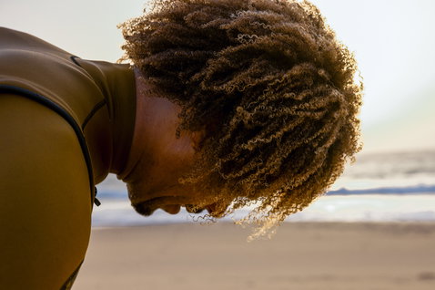 ION Seek Core 3/2mm front-zip long-sleeve shorty wetsuit in olive brown during kitesurfing at the beach