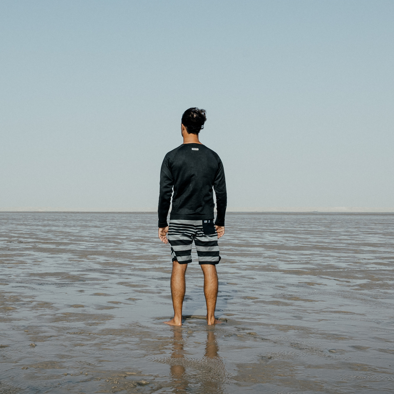 ION Surf Shield Wetshirt LS Langarm-Rashguard in schwarz beim Surfen am Meer