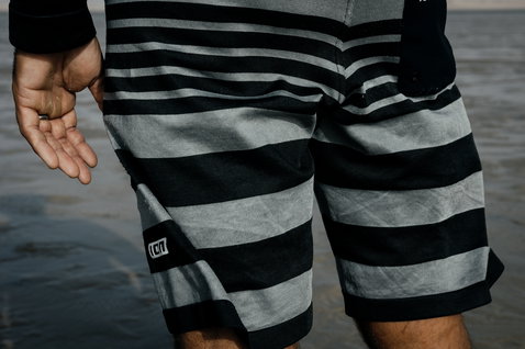 ION Surf Shield boardshorts 20" in nero e grigio durante il surf in mare